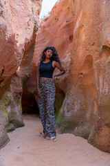 A woman is posing in a cave with her back to the camera