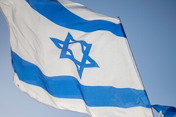 High resolution close up color image of an Israeli flag in the wind with a blue background