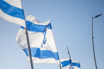 High resolution close up color image of an Israeli flag in the wind with a blue background