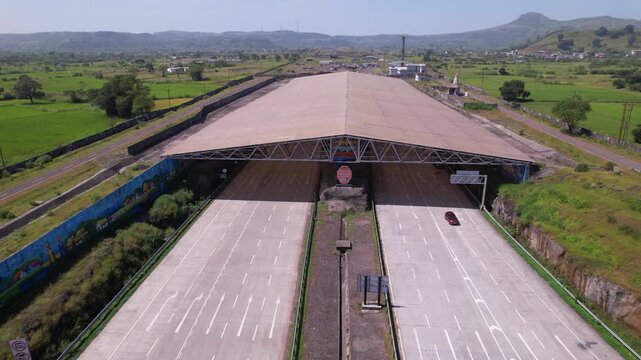 Igatpuri Kasara tunnel on Samruddhi Mahamarg through rural village with agricultural fields, western ghats landscape, Maharashtra, drone shot