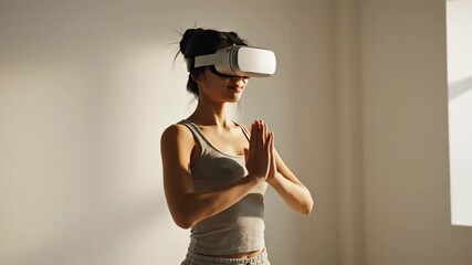 Young asian woman performing virtual reality meditation and yoga in vr headset at home footage - Powered by Adobe