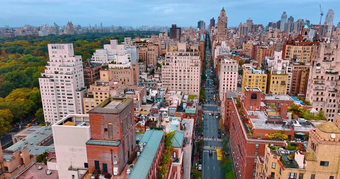 Flying over the highway with heavy traffic. Aerial perspective on the scenery of New York and beautiful greenery of Central Park.