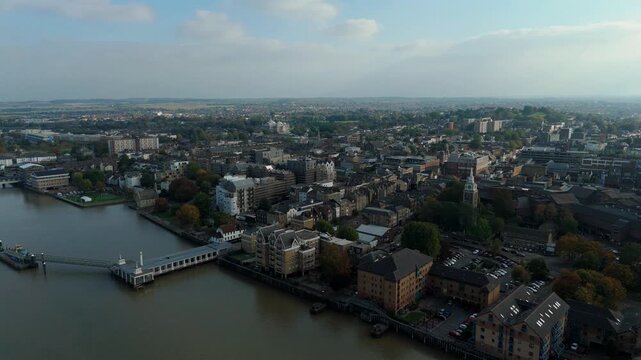 Aerial drone shot of Gravesend town, with jetty and buildings in evening light across River Thames near London, United Kingdom 