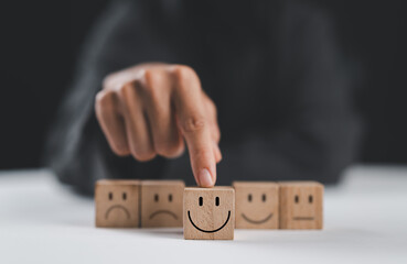 customer services best excellent business rating experience. Satisfaction survey concept. Hand of a businesswoman chooses a smile face on wood block. 5 Star Satisfaction.