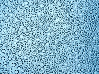 Drops of Water blue abstract background. Wet Rain Splash texture. water droplets on glass surface in rainy day. top view full frame image