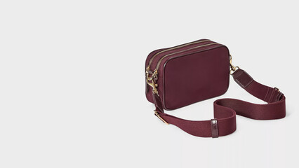 Stylish burgundy crossbody bag with adjustable strap for versatile fashion choices.