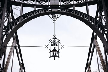 A lamp hanging high on a bridge