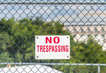 NO TRESPASSING sign on a chain link fence