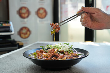 돼지목살 불고기를 젓가락으로 집은 모습