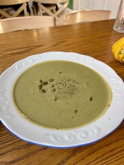 Pumpkin and broccoli puree cheese soup served on a beautiful, elegant plate