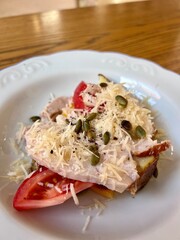 Salad with chicken breast, cheese and tomatoes on an elegant plate