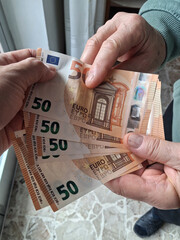 Banconote da 50 che passano da una mano all'altra - business o tangente