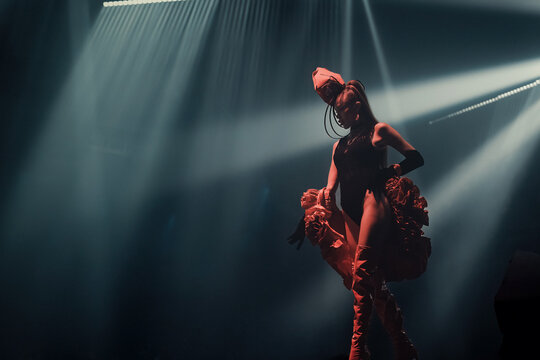 Avant-garde nightclub performer on stage&mdash;elegant, seductive and powerful. Dramatic spotlights, cinematic haze and confident pose create a high-fashion, theatrical party vibe.