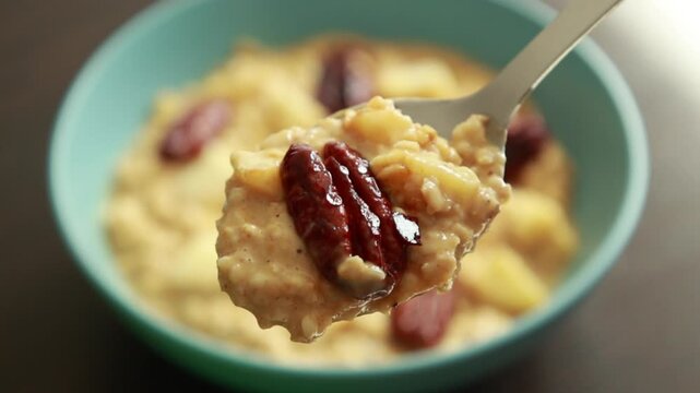 creamy pumpkin oatmeal topped with fresh apple slices and caramelized pecans