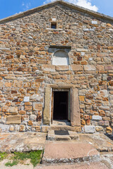 Fototapeta premium Ancient stone wall facade with doorway and windows at Church of the Holy Apostles Peter and Paul, Novi Pazar, Serbia