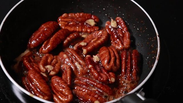 pecan nuts caramelizing in a pan