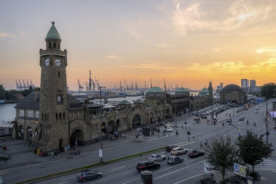 St. Pauli Landungsbr&uuml;cken with the tide gauge tower and the Elbe, Hamburg harbour in the background, at sunset, Hamburg, Germany