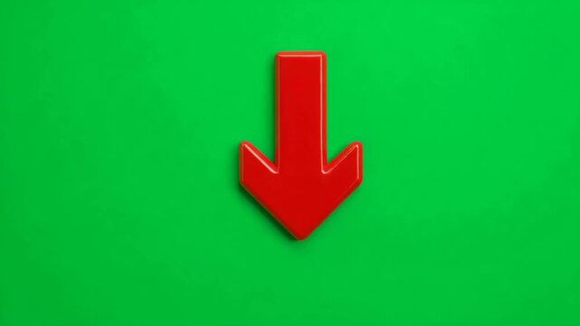 Red arrow pointing downward on a green chroma key screen background. Concept of decrease, loss, or decline for business and finance. Isolated object point down on chromakey backdrop.