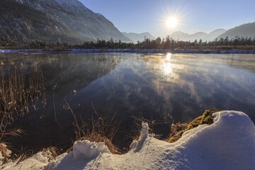 Mountains reflected in lake, evening light, sunbeams, snow, winter, seven springs, behind Zugspitze, Alpine foothills, Bavaria, Germany