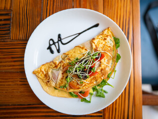 Top view omelet with greens tomato and sprouts on plate