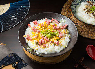 Bowl of Corn and Ham rice porridge topped with corn and meat, perfect for a comforting and flavorful meal. Enjoy this savory dish for breakfast, lunch, or dinner.