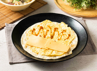Delicious Puff pastry cheese omelet egg pancake with cheese and sauce, a tasty dish perfect for breakfast, brunch, or a delightful snack any time of day. The balanced meal is a culinary delight