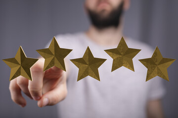 A man points to golden stars representing rating and satisfaction. Concept of feedback, success,...