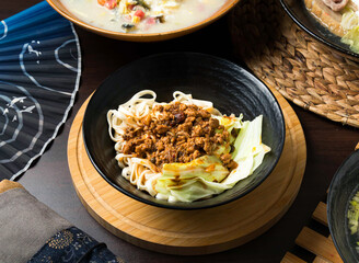 Spicy noodle bowl with meat and cabbage, perfect for recipe blogs or restaurant promotions. Evokes a sense of delicious Asian cuisine and culinary delight