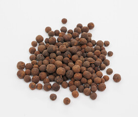 Pile Of Brown Allspice Berries On White Background For Cooking, Spice, And Food Photography