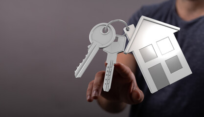 Close-up of a hand offering a house keychain and keys, symbolizing real estate, home ownership,...