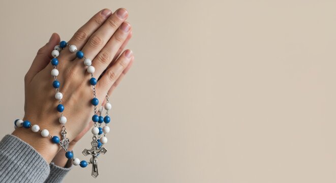 Praying hands with rosary beads on neutral background for spiritual reflection and religious design