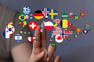 A hand pointing to a selection of country flags, representing international concepts like globalism, travel, diversity, and choice.