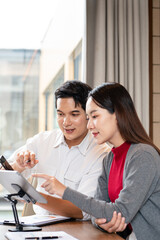 Confident mature business professional man talking to younger female colleague at office table,...