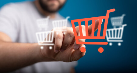 Close-up of a hand interacting with a shopping cart icon representing online shopping, digital...