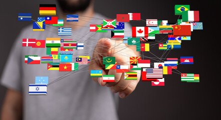 A person connecting multiple national flags, representing globalization, international cooperation,...