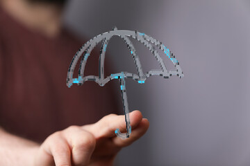 Conceptual image of a hand holding a digital umbrella representing security, protection, and...