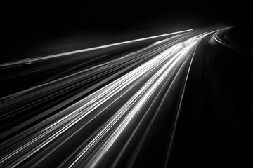 Long exposure photograph of car light trails on a dark highway curve