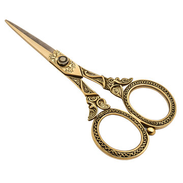 These beautifully ornate golden scissors display intricate patterns, resting elegantly closed against a stark black background, perfect for craft or decoration.