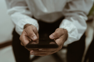 Obraz premium Focus on a person's hand using a mobile phone.
