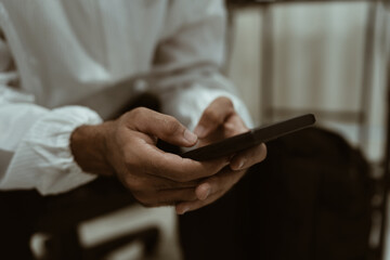 Fototapeta premium Focus on a person's hand using a mobile phone.