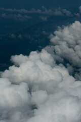 View of White Clouds from Airplane Window. Beautiful aerial view of soft white clouds from an airplane window during flight. The peaceful atmosphere of the sky above the clouds.
