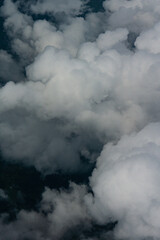 View of White Clouds from Airplane Window. Beautiful aerial view of soft white clouds from an airplane window during flight. The peaceful atmosphere of the sky above the clouds.