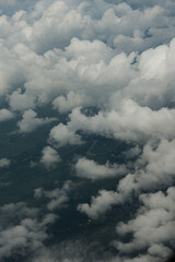 View of White Clouds from Airplane Window. Beautiful aerial view of soft white clouds from an airplane window during flight. The peaceful atmosphere of the sky above the clouds.