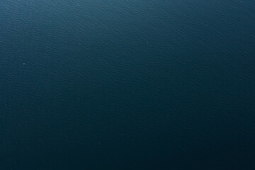 Aerial View of Calm Blue Sea Surface. Minimalist aerial view of deep blue ocean water with gentle ripples. Tranquil natural background for travel, marine, and nature concepts.