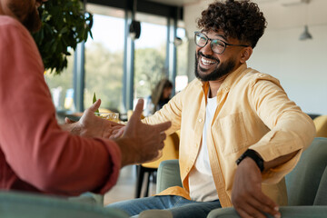 Young men laughing enjoying conversation at cafe