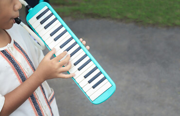 kid student playing on melodeon in morning of sport day activity