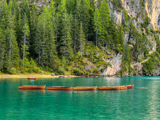 Lago di Braies or Lake Braies crystal blue lake with wooden rowing boats in Italian Dolomites....