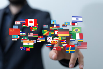 A person's hand touching a collection of world flags, symbolizing global connection, international cooperation, and the concept of travel. This