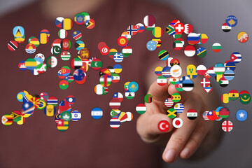 Hand touching world flags. Represents globalization, diversity, unity, international collaboration, and global concepts. Ideal for visuals about