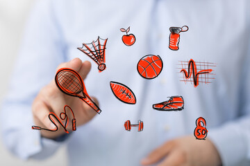 Person interacting with a futuristic digital display featuring vibrant, hand-drawn sports and health icons. Concepts of active living, wellness